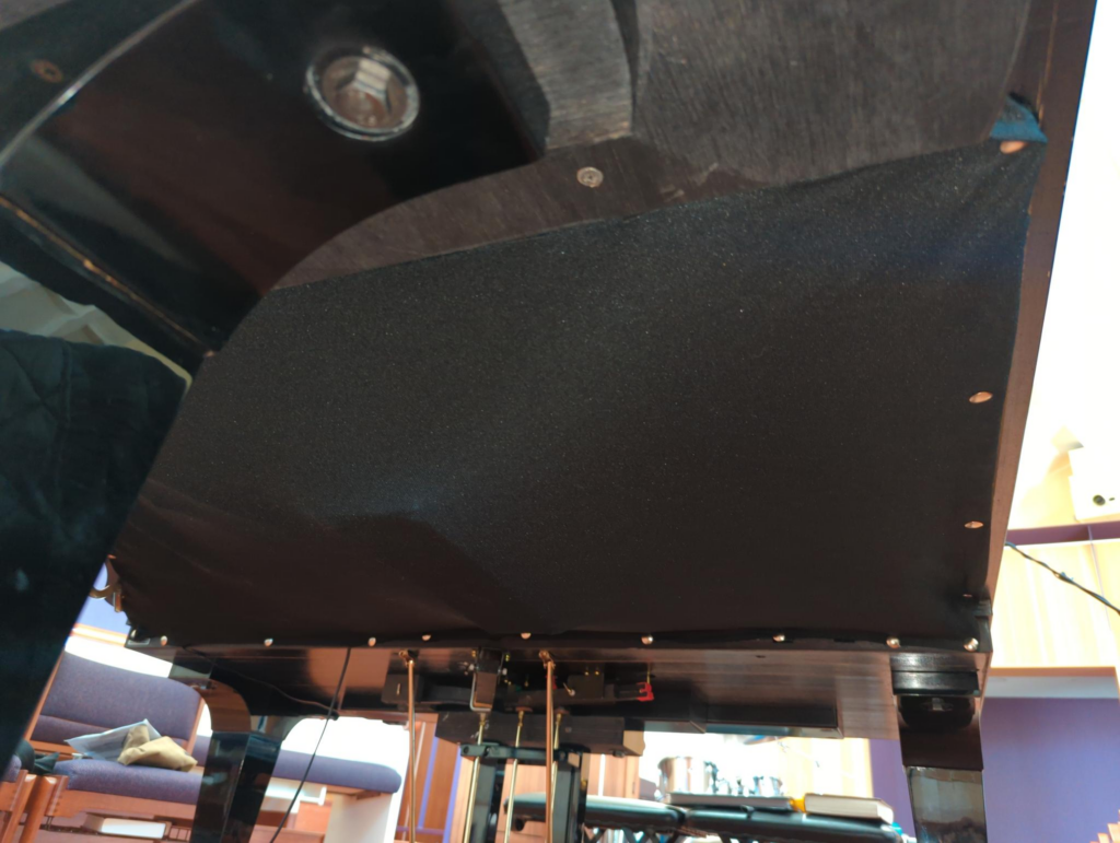 View of Dampp-Chaser undercover installed underneath Boston grand piano.