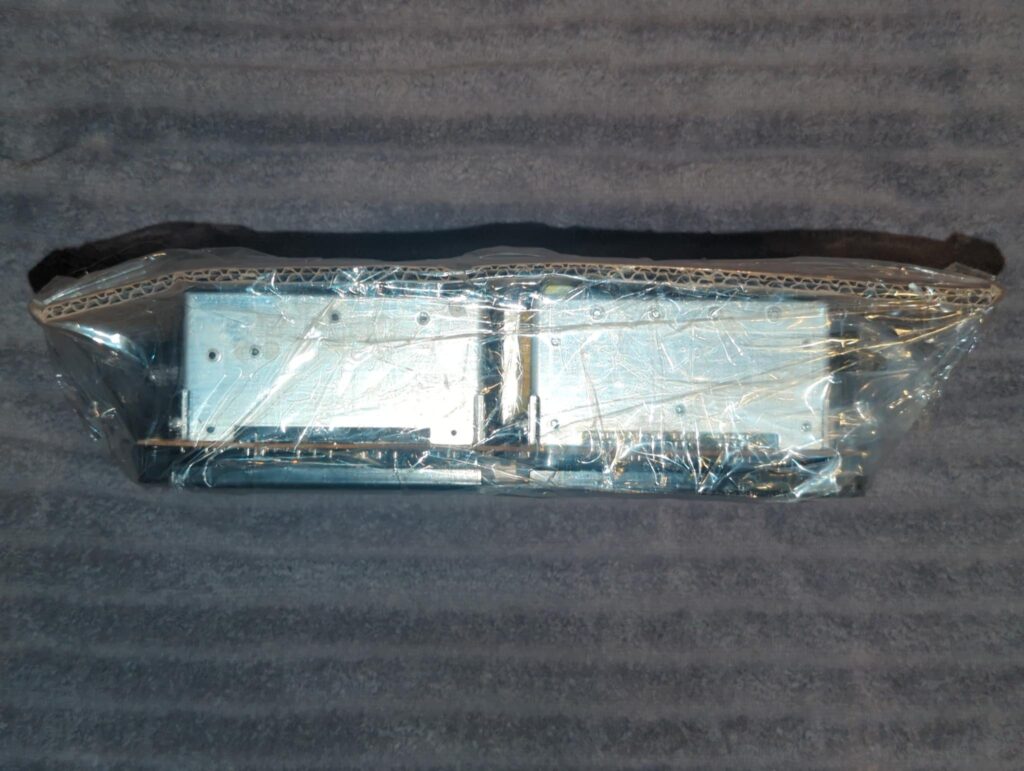 A power supply shipped from TAP Electronics. Note that they use a large cardboard panel to protect one side of the power supply.