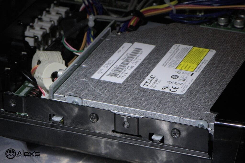 The other two screws are on the outside of the CD drive. Also visible are the tiny metal tabs: Just shift the CD drive slightly toward the inside of the case to release it.