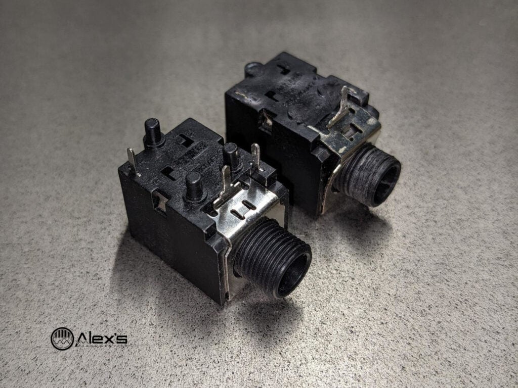 Two 1/4" audio output jacks, with a new one in the foreground and a damaged one in the background.