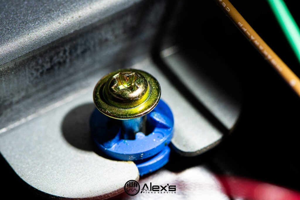 Closeup of screw with metal spacer and rubber grommet.