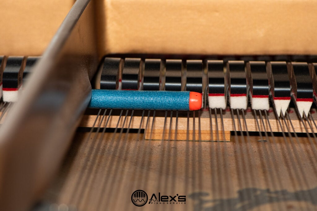 NERF dart on piano strings inside a piano.