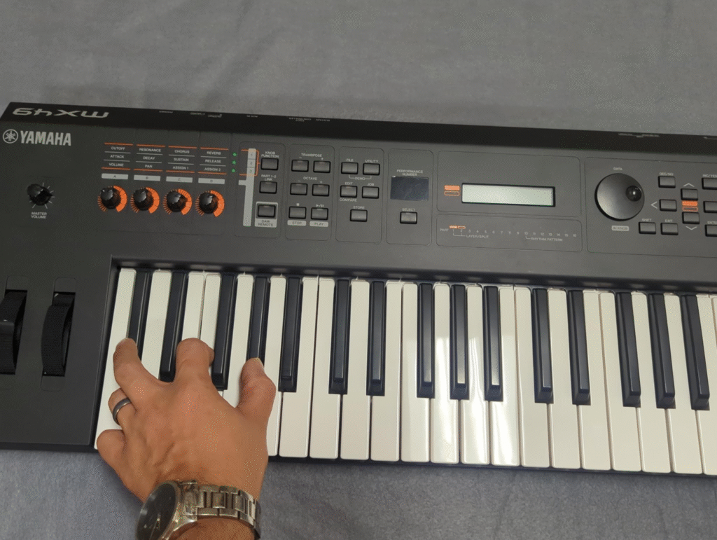 Pressing the C#, F, and G# keys on a Yamaha MX49.