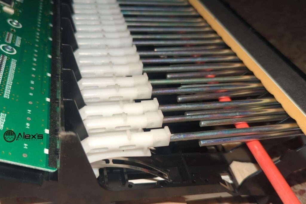 A fiberglass rod inserted into a Yamaha GH action to prevent hammer motion during repair.