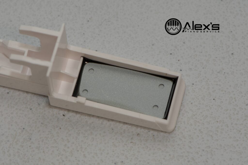 Close-up of lead weight installed under new Roland keyboard key.