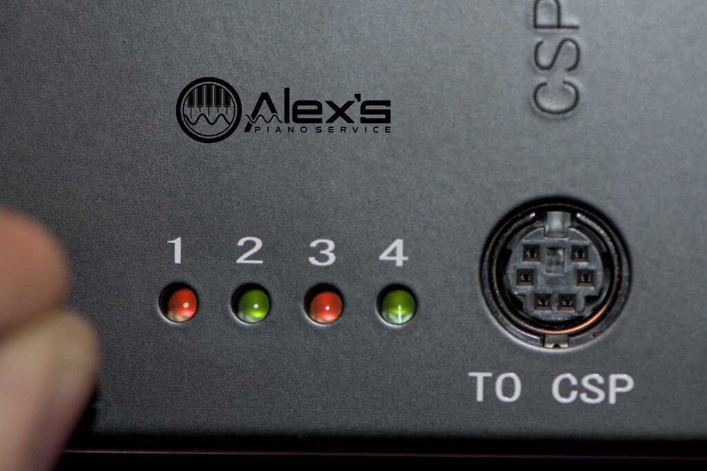 Closeup of Yamaha E3 Disklavier power supply, with all four test lights lit up. Lights #1 and #3 are orange, and lights #2 and #4 are green.